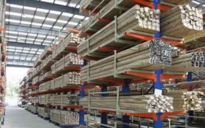 Here is a picture of a warehouse full of blue and orange-coloured double-sided cantilever racking systems storing long aluminium extrusions.