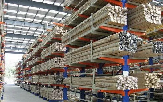 Warehouse full of blue and orange coloured double sided Cantilever Racking storing long products.