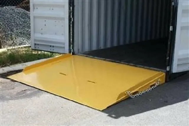 A yellow Container Ramp with side guides positioned at the entrance of a Shipping Container