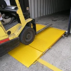 A bi-fold yellow access plate with a forklift driving up it