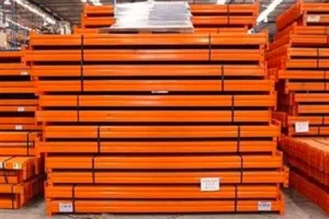 Orange coloured Used Racking Beams stacked in packs on top of one aother.